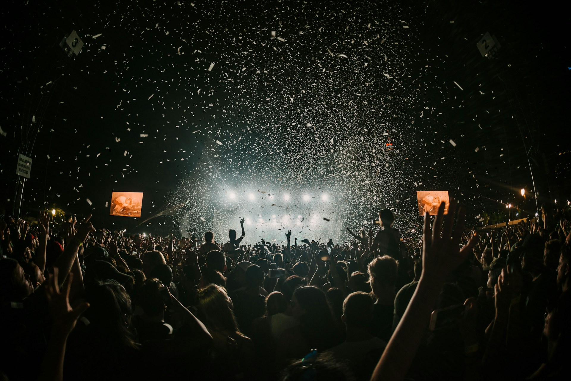 Festival met handen in de lucht en gekleurde rookeffecten