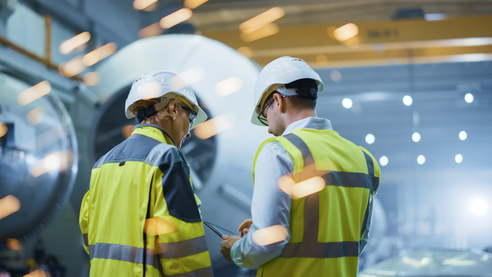 2 medewerkers in industriele omgeving aan het overleggen